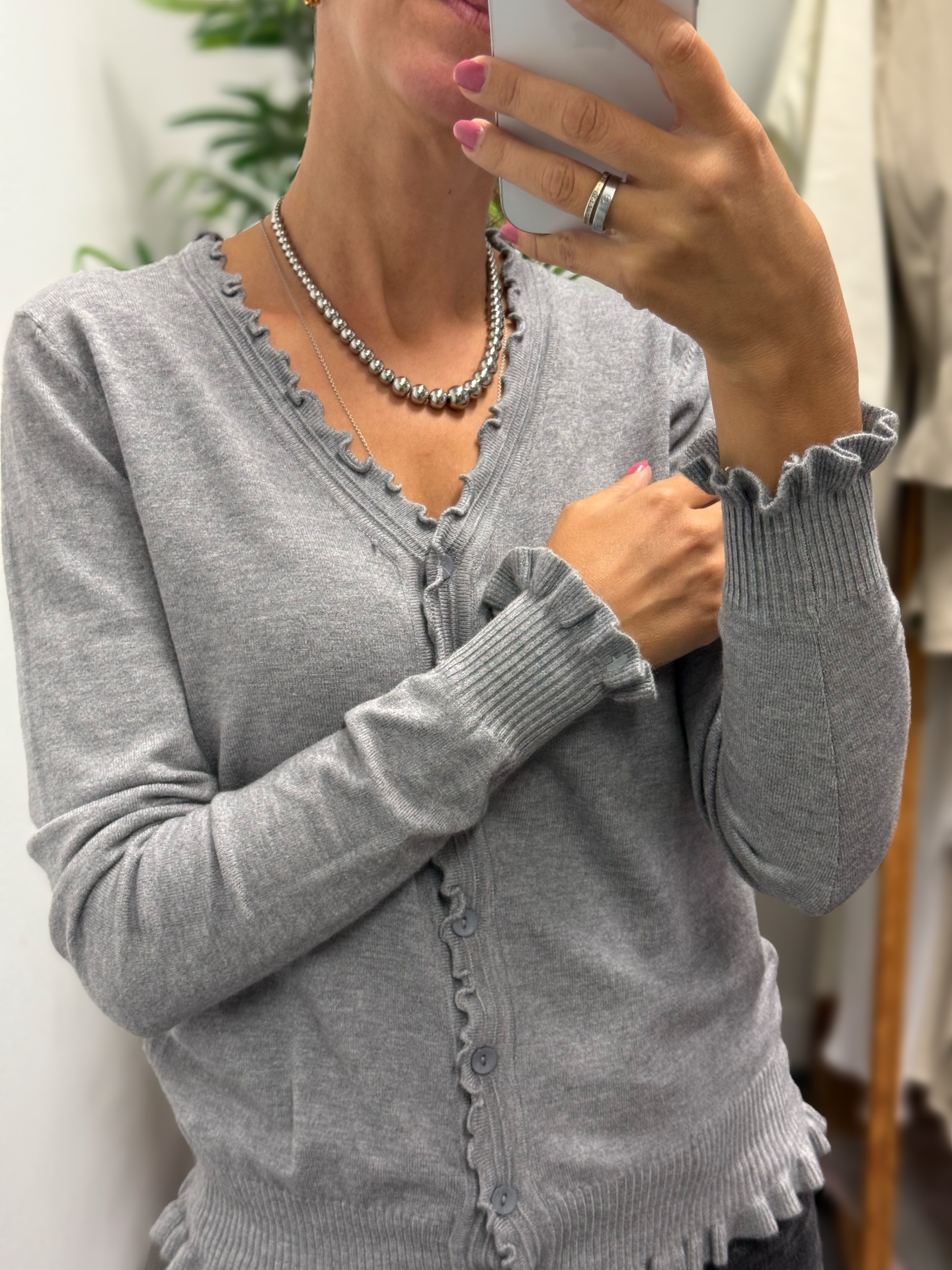 Camisola cinza de malha com botões e detalhes ondulados