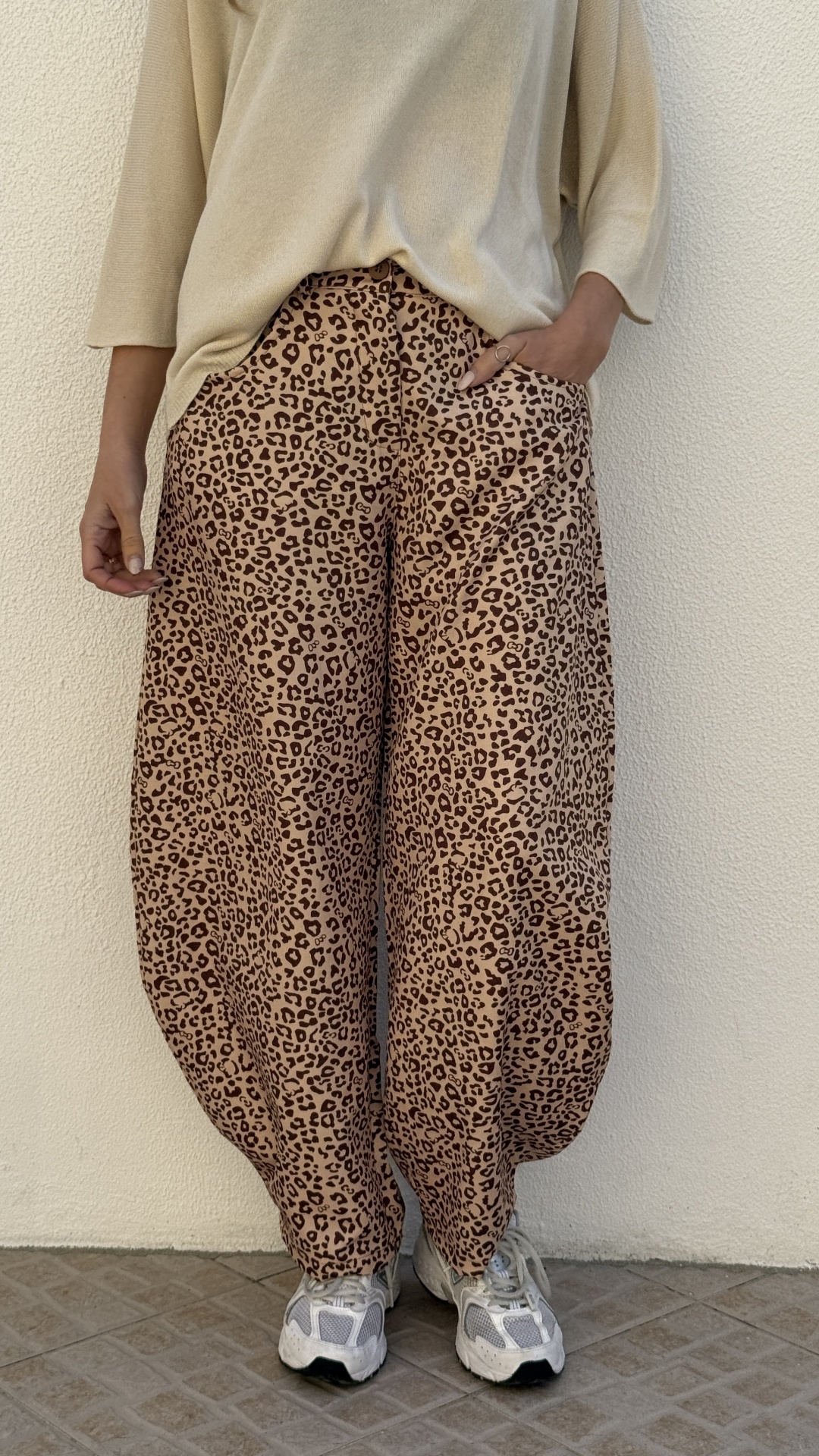 Calças largas animal print castanho e bege com top bege e sapatilhas brancas.