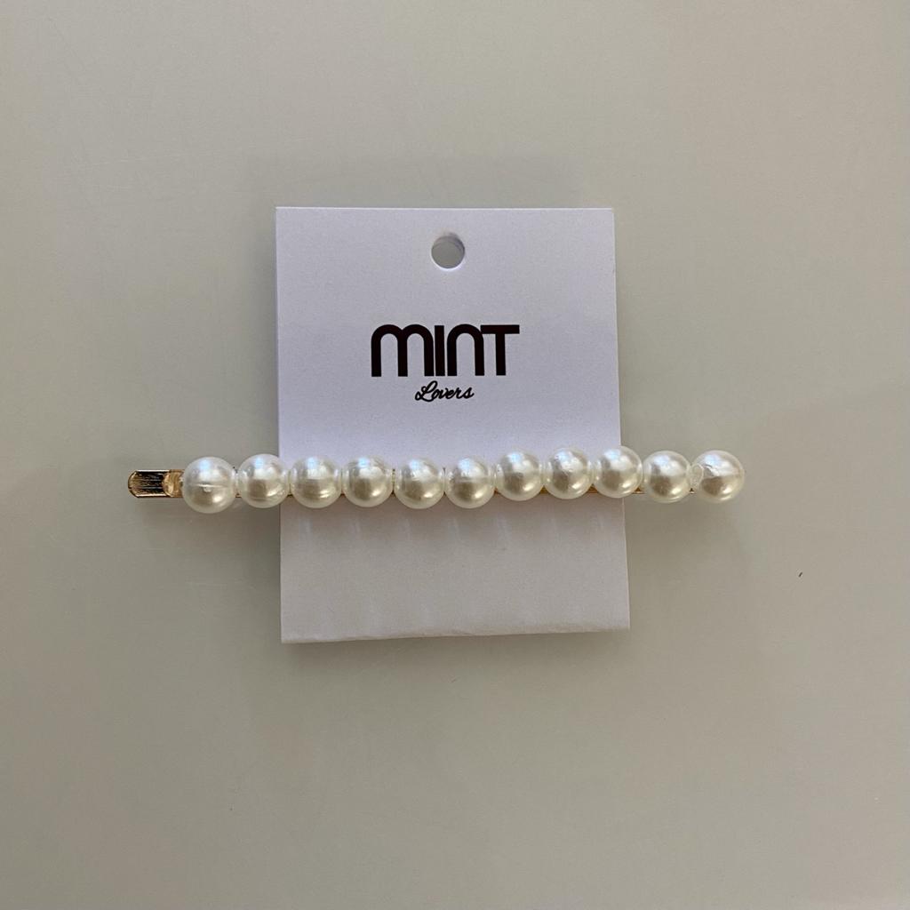 Presilha de cabelo com pérolas em suporte dourado sobre cartão branco com marca MINT Lovers