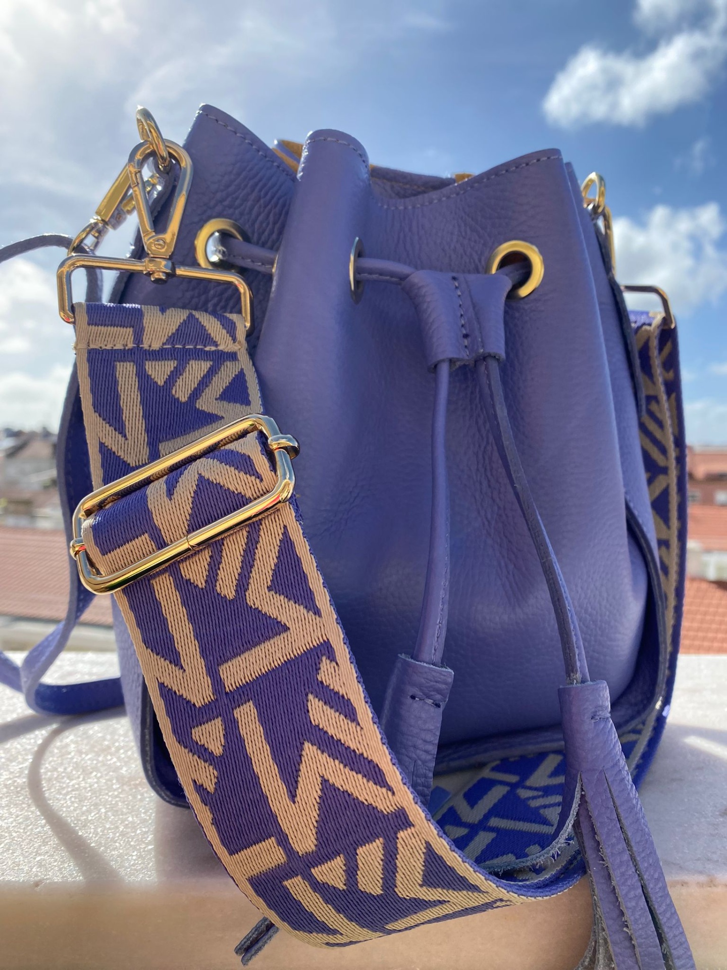 Mala de mão roxa em pele com alça larga estampada azul e bege