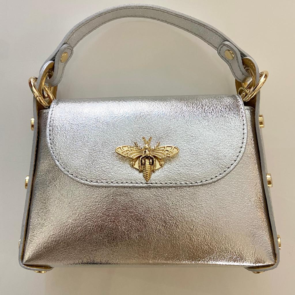 Mala de mão pequena prateada com adereço dourado em forma de abelha