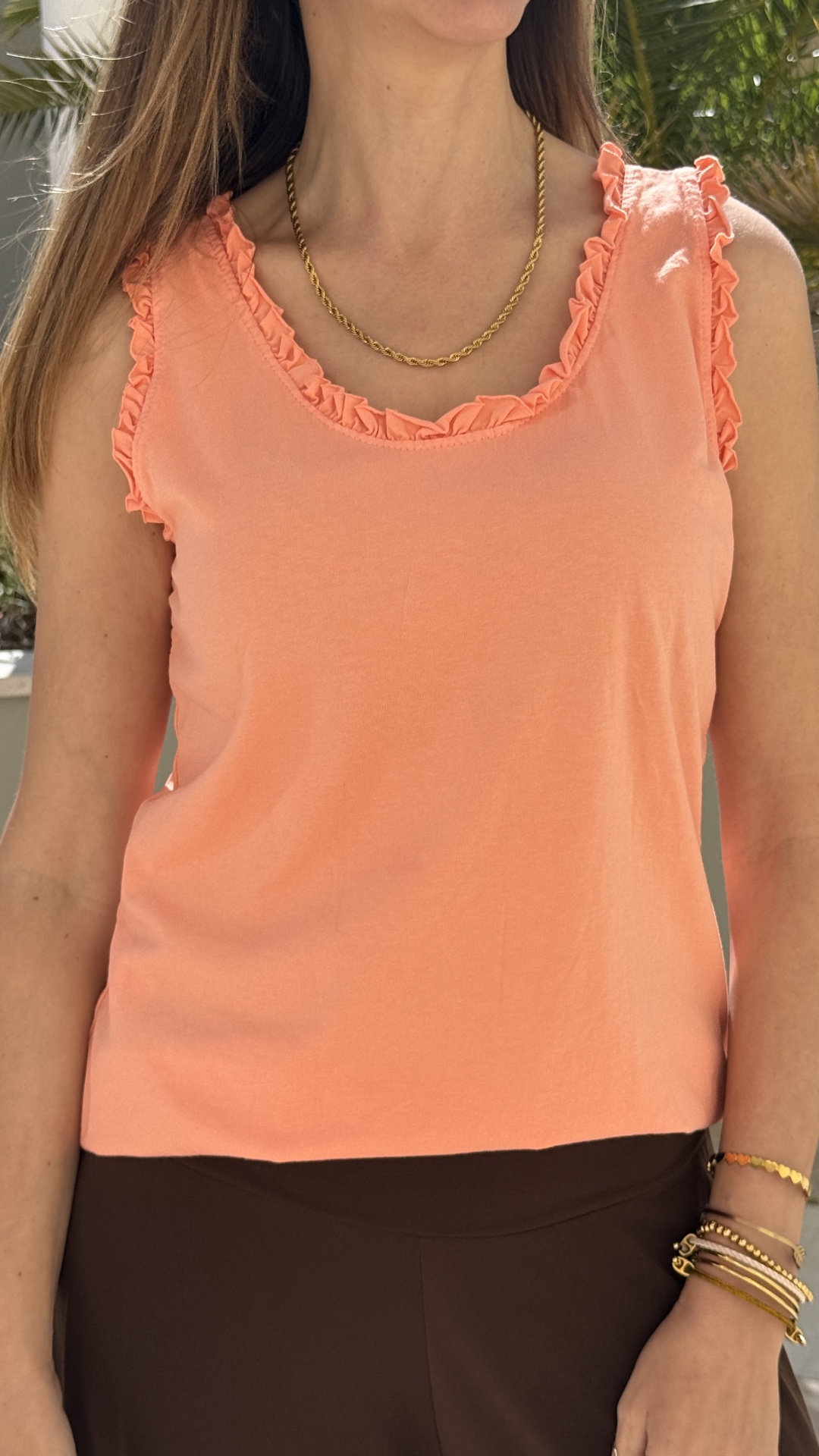 Top feminino cor de pêssego com folhos e colar dourado