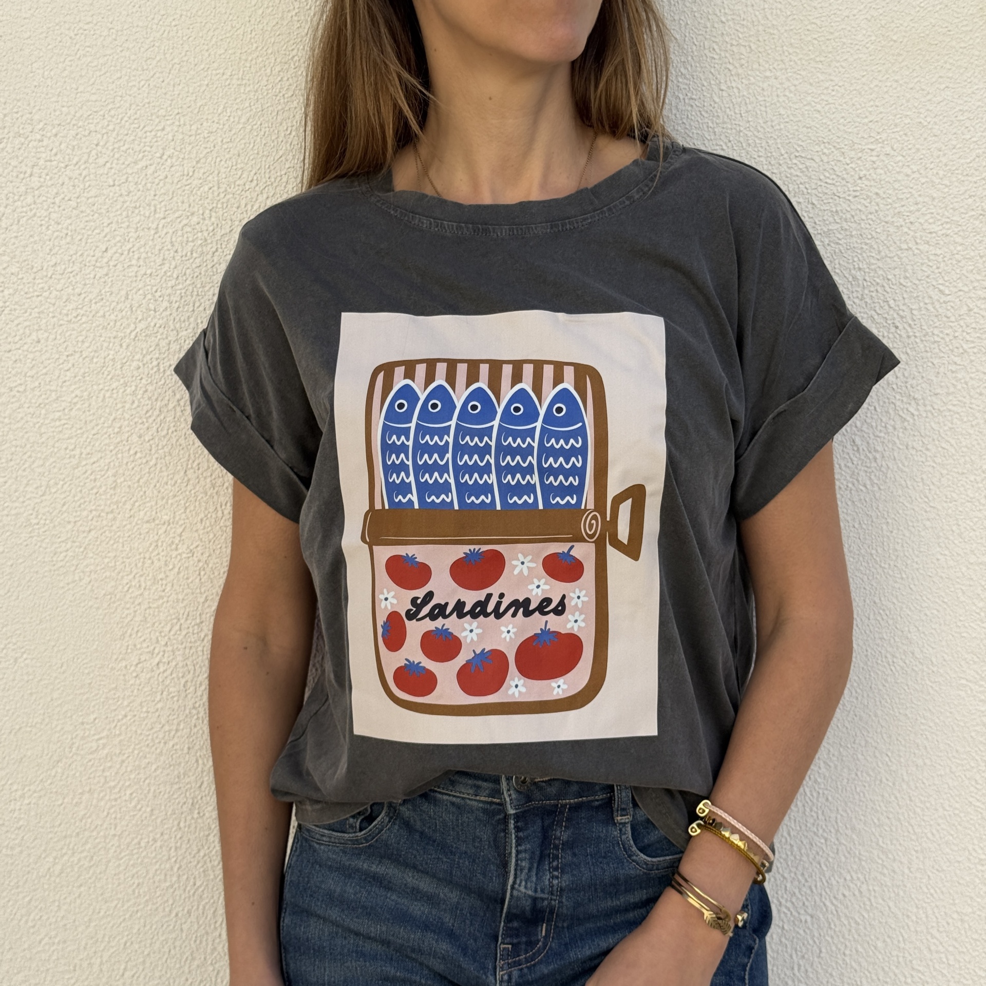 T-shirt cinza escuro com estampa de lata de sardinhas cor de azul e tomates vermelhos.