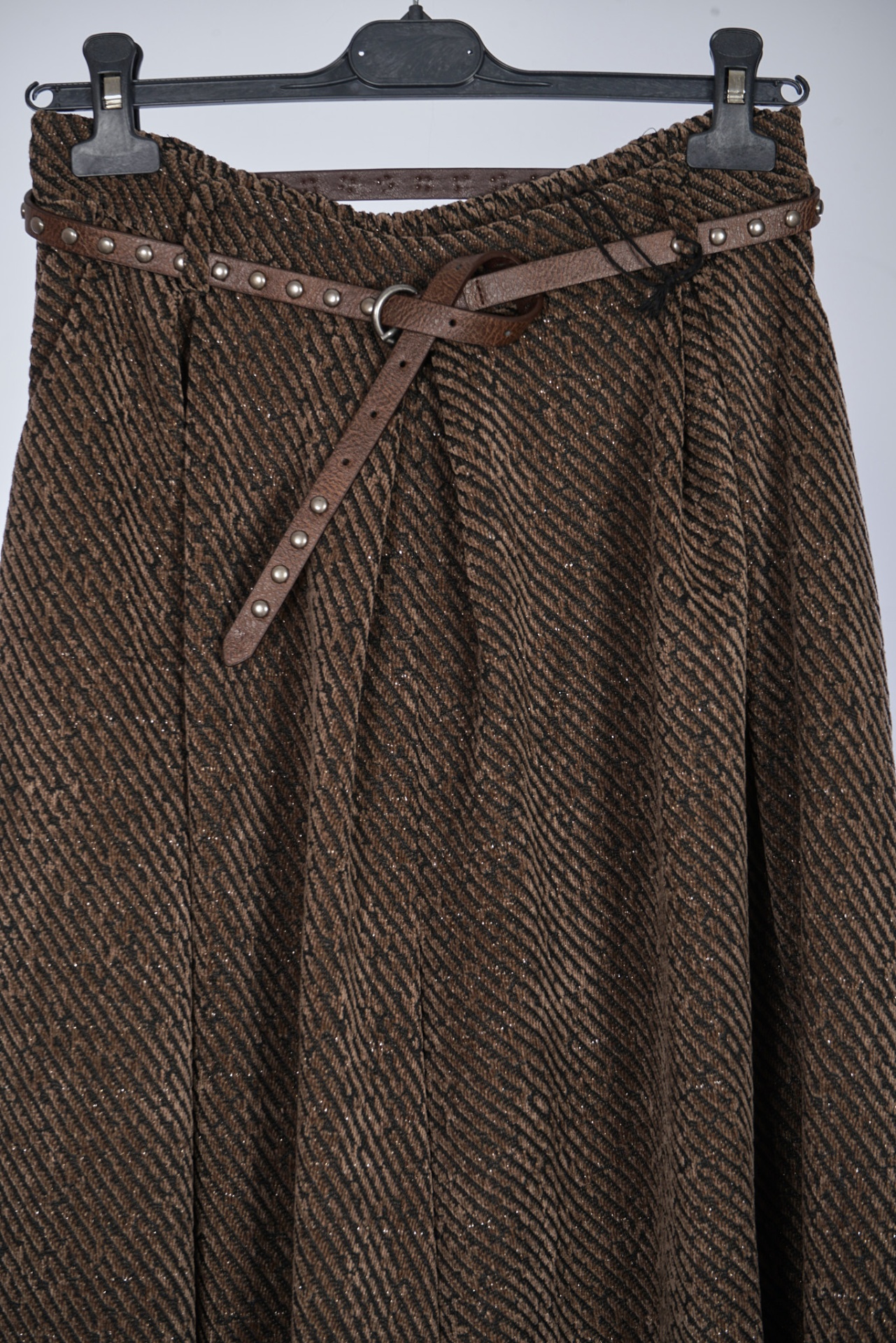 Saia castanha com padrão listrado e cinto com tachas prateadas