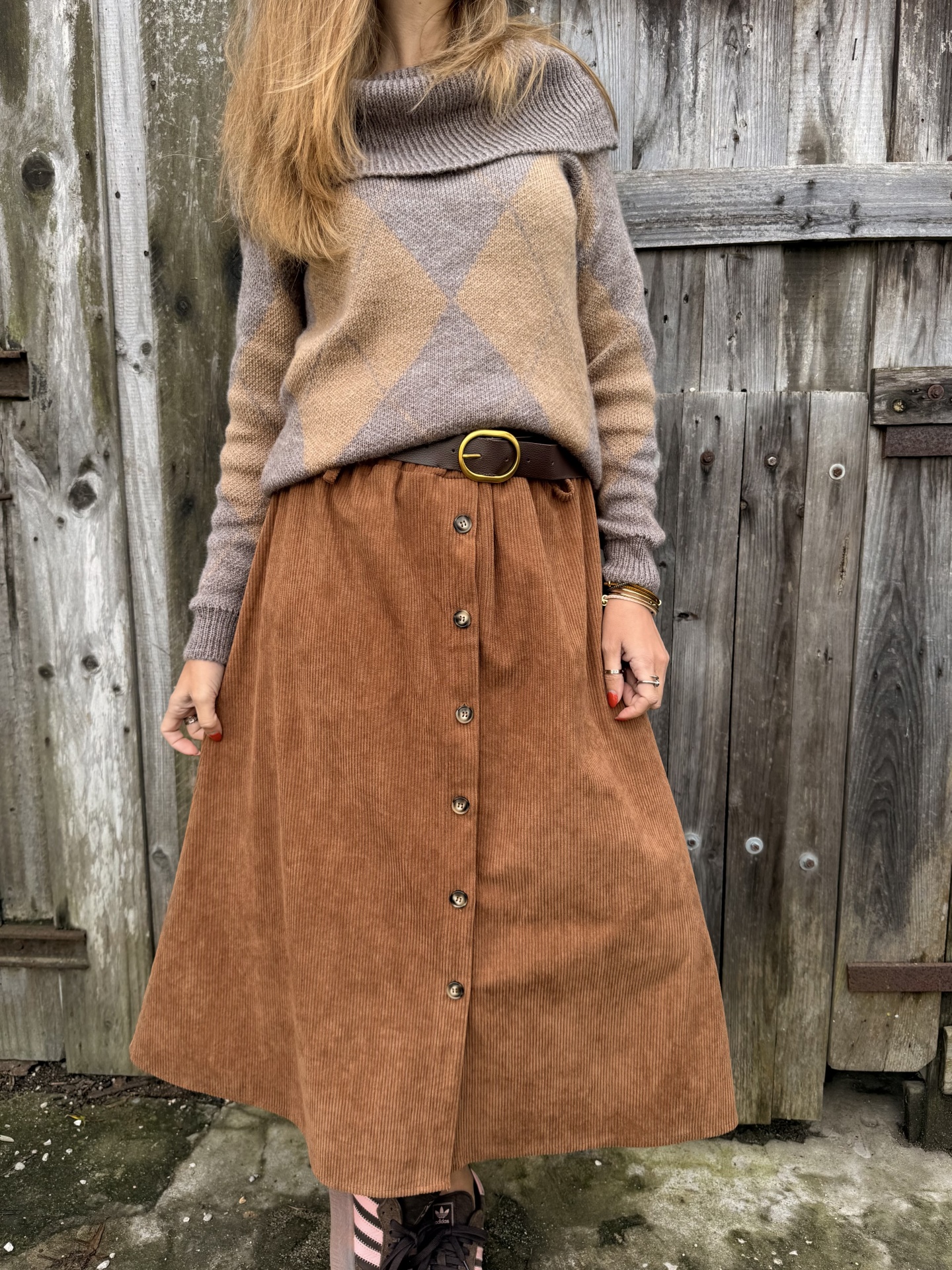 Saia midi de veludo cotelê castanha com botões e camisola bege com padrão de losangos