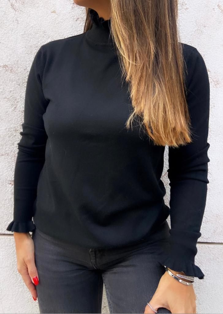 Camisola preta de malha com gola alta e detalhe nas mangas, usada com calças pretas