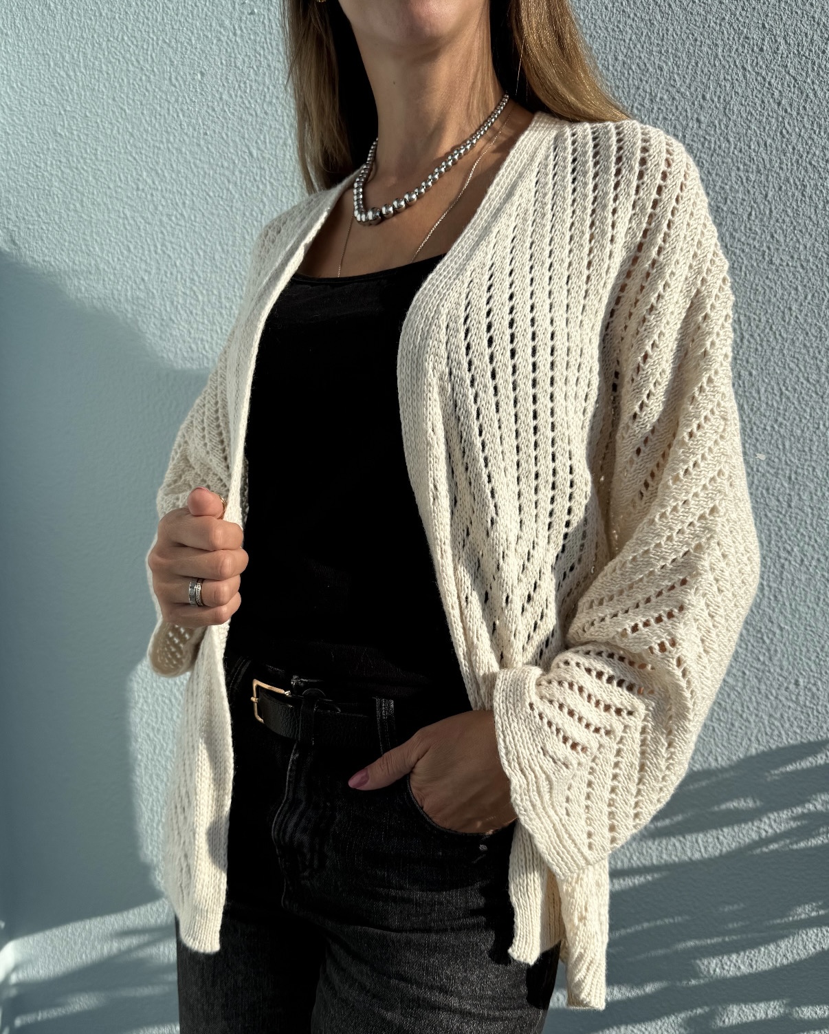 Cardigan creme rendado com blusa preta e calças pretas