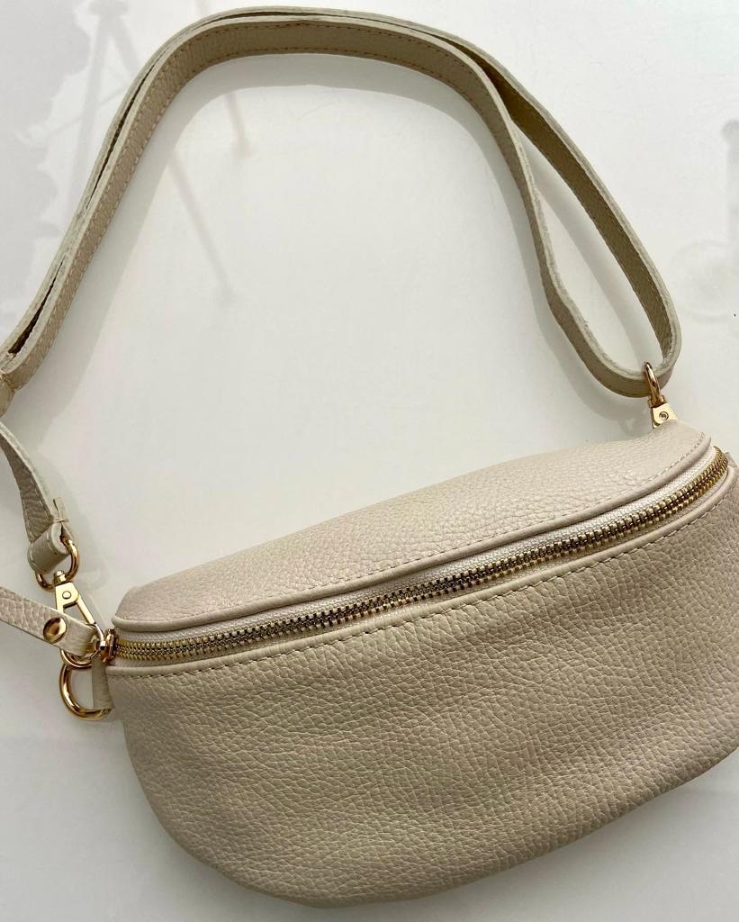 Bolsa bege claro tipo pochete com zíper dourado e alça ajustável