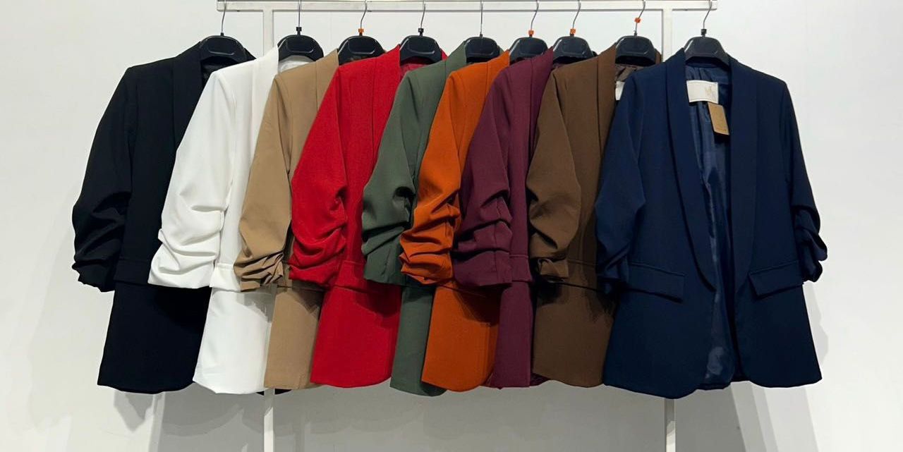 Blazers femininos em várias cores sólidos pendurados em cabides pretos