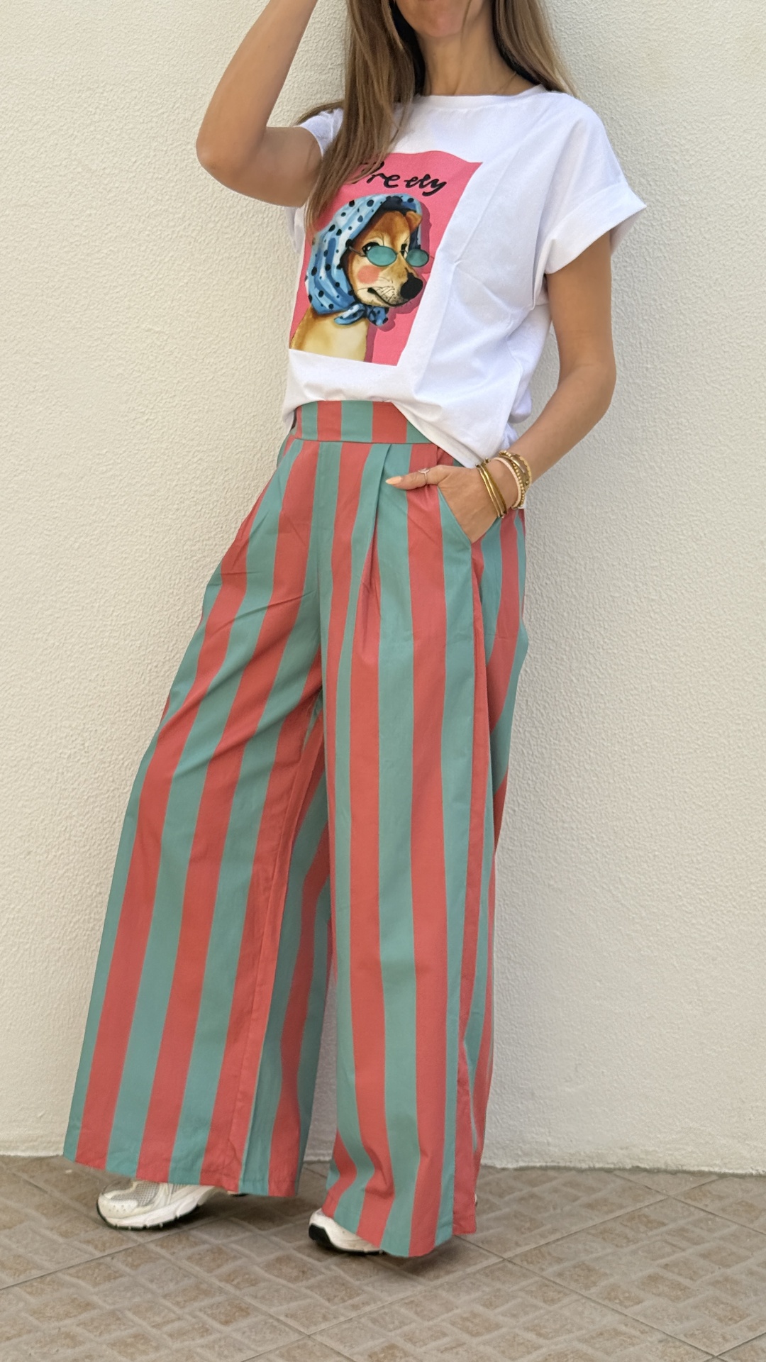 Calças riscas coral e verde água, t-shirt branca com estampa de cão, sapatilhas brancas