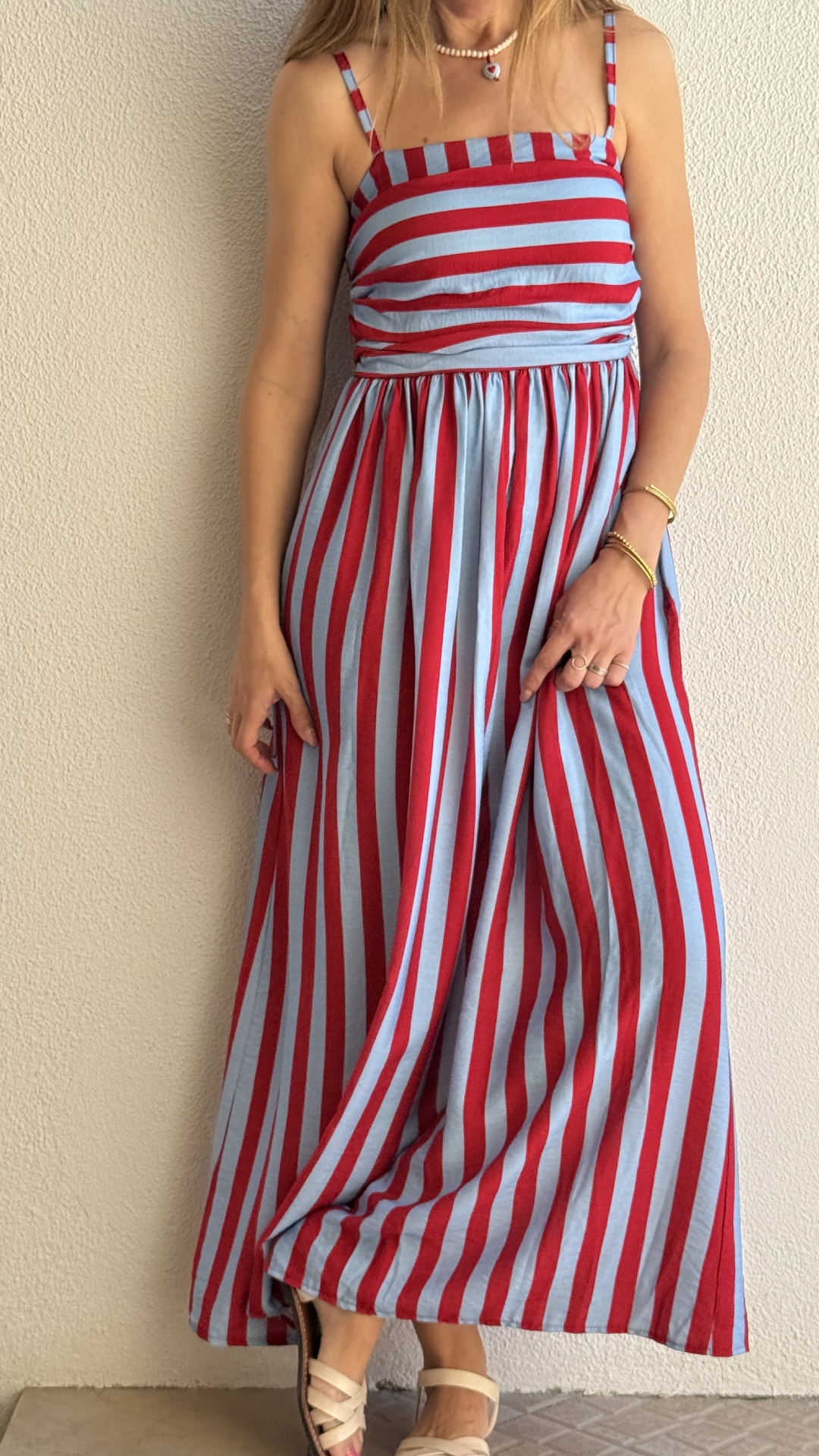 Vestido riscado vermelho e azul claro com alças finas em modelo feminino