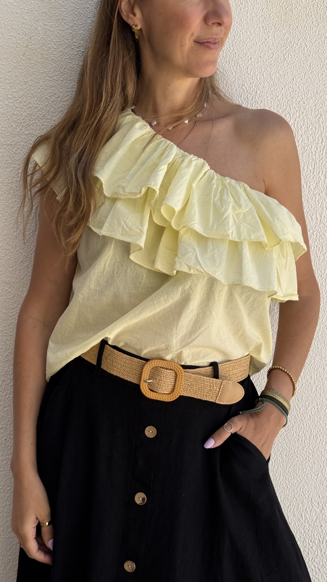 Blusa amarela com folhos e saia preta com cinto bege