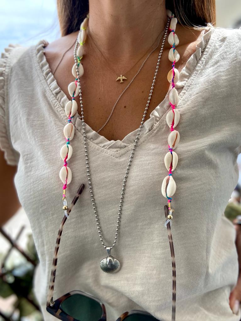 Cordão para óculos com conchas brancas e linhas coloridas em t-shirt branca