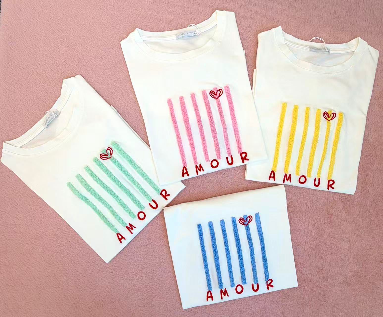 T-shirts brancas com riscas coloridas e palavra AMOUR
