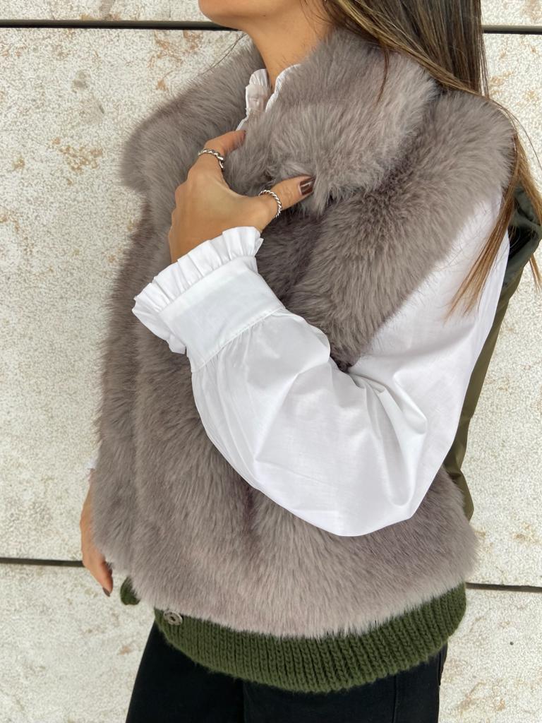 Casaco sem mangas de pelo cinzento com barra de malha verde e camisa branca