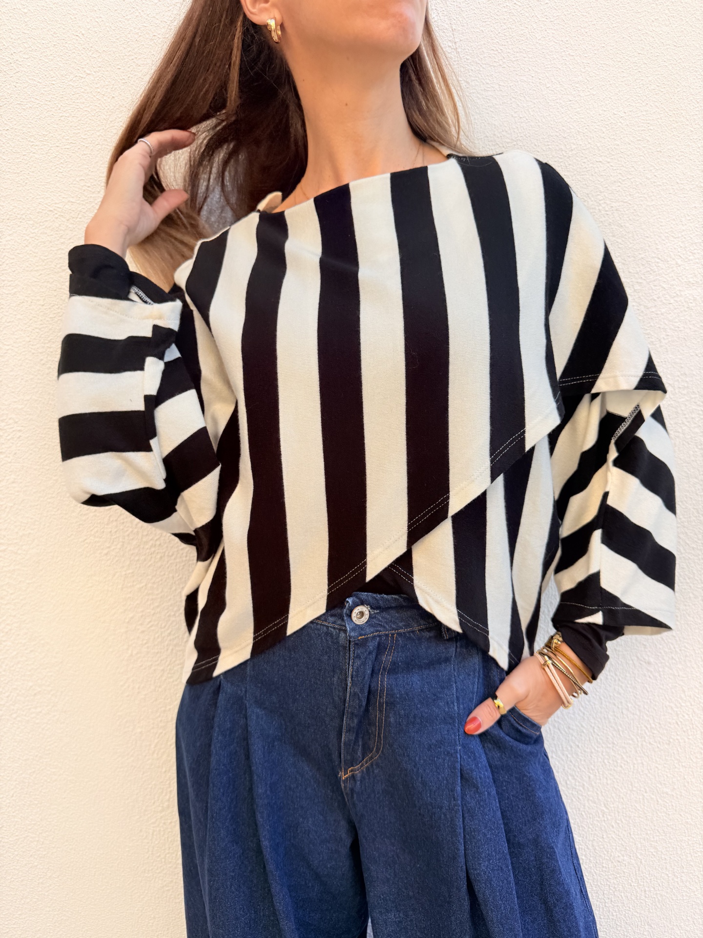 Mulher com blusa listrada preta e branca e jeans azul