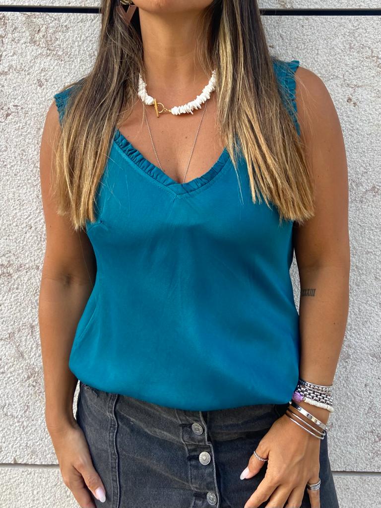 Blusa azul turquesa sem mangas com decote em V e saia preta de botões