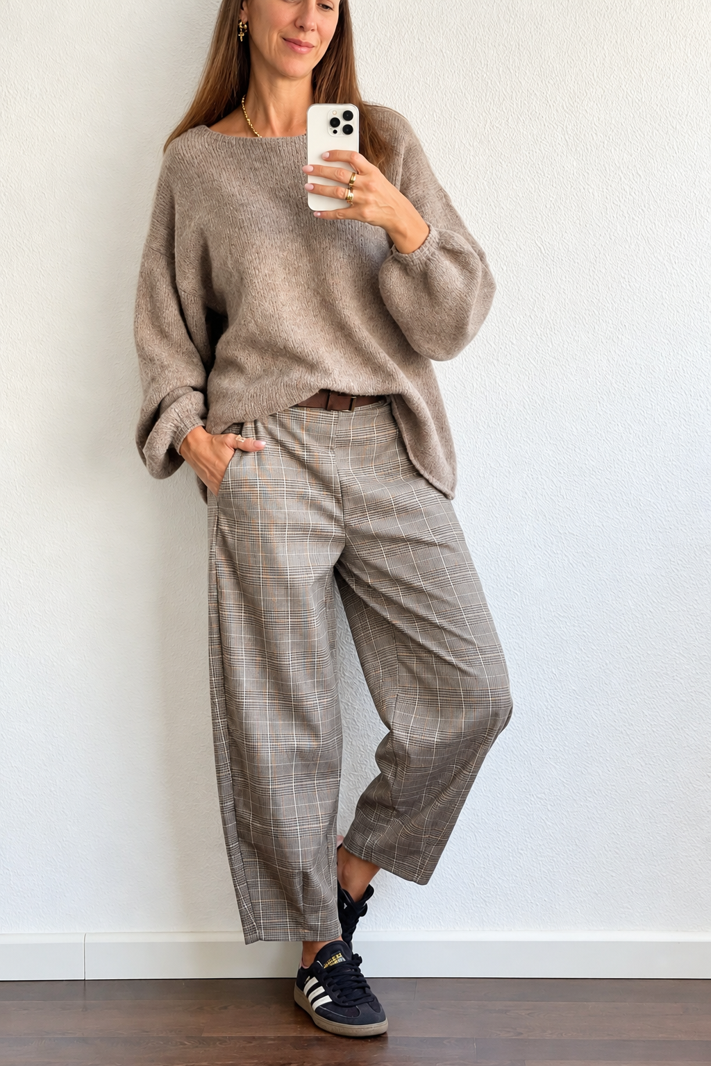 Mulher a usar moda casual com camisola castanha e calças xadrez