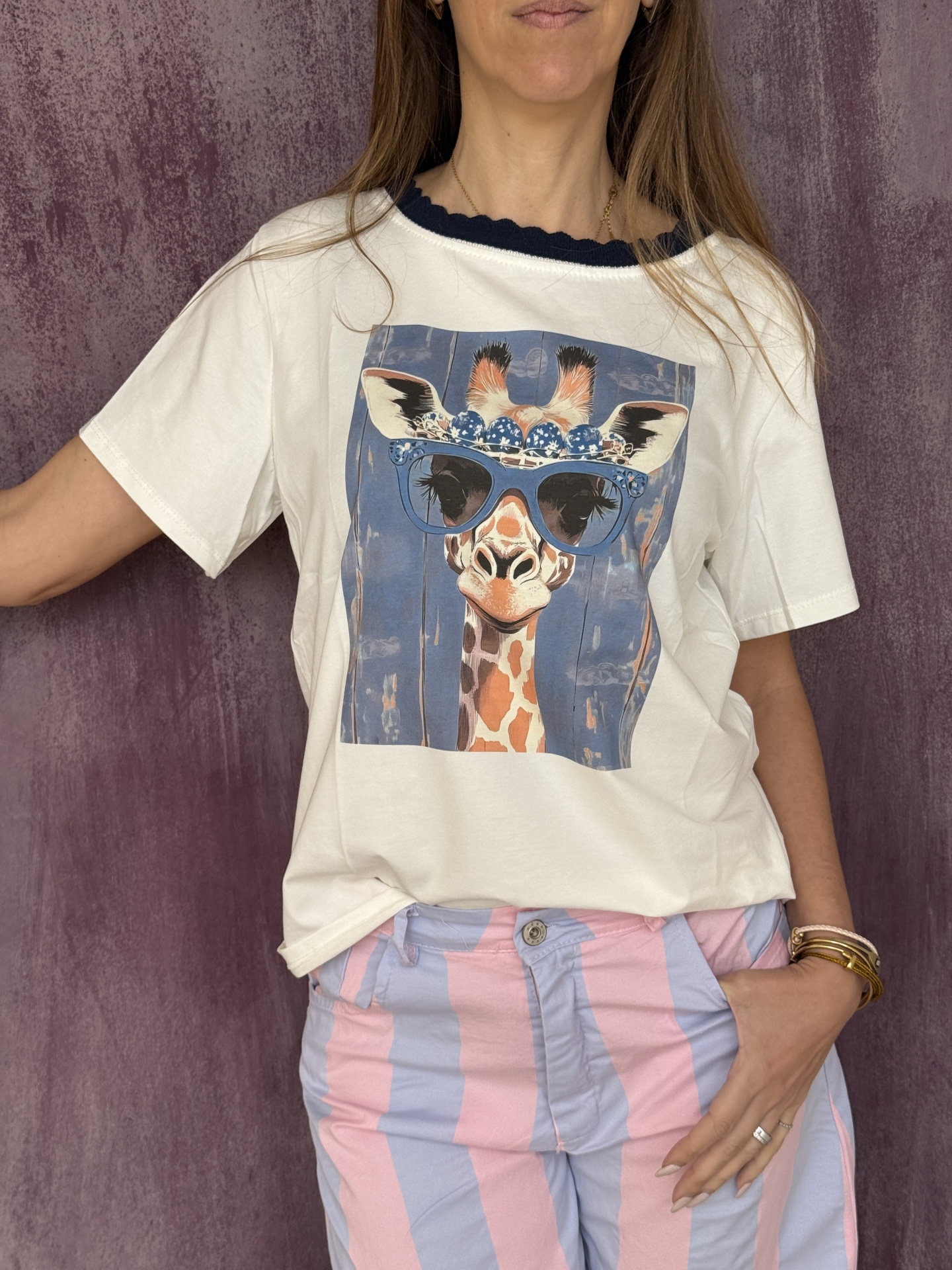 T-shirt branca com estampa girafa de óculos e calças listradas azul claro e rosa