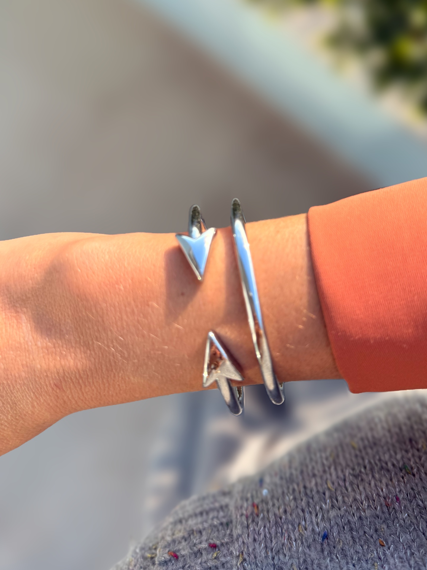 Pulseira em metal prateado com pontas triangulares no pulso