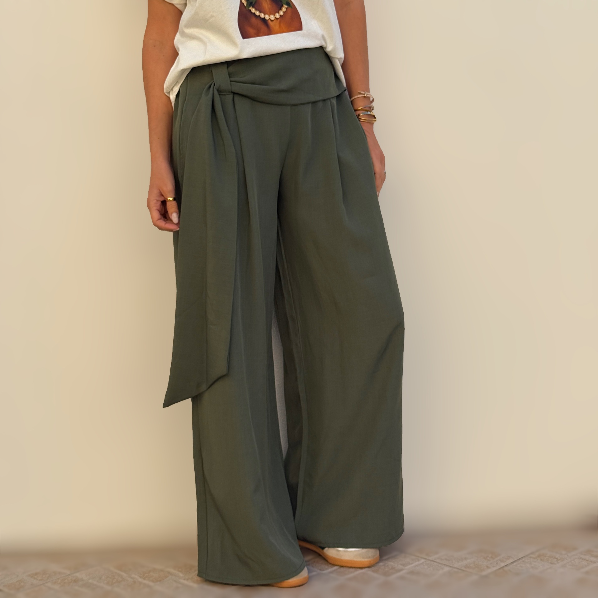 Calças largas verdes com faixa na cintura e t-shirt branca.