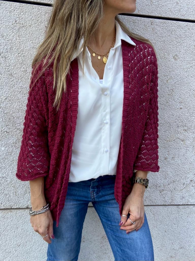 Casaco malha vinho com padrão ajourado, camisa branca e jeans azul