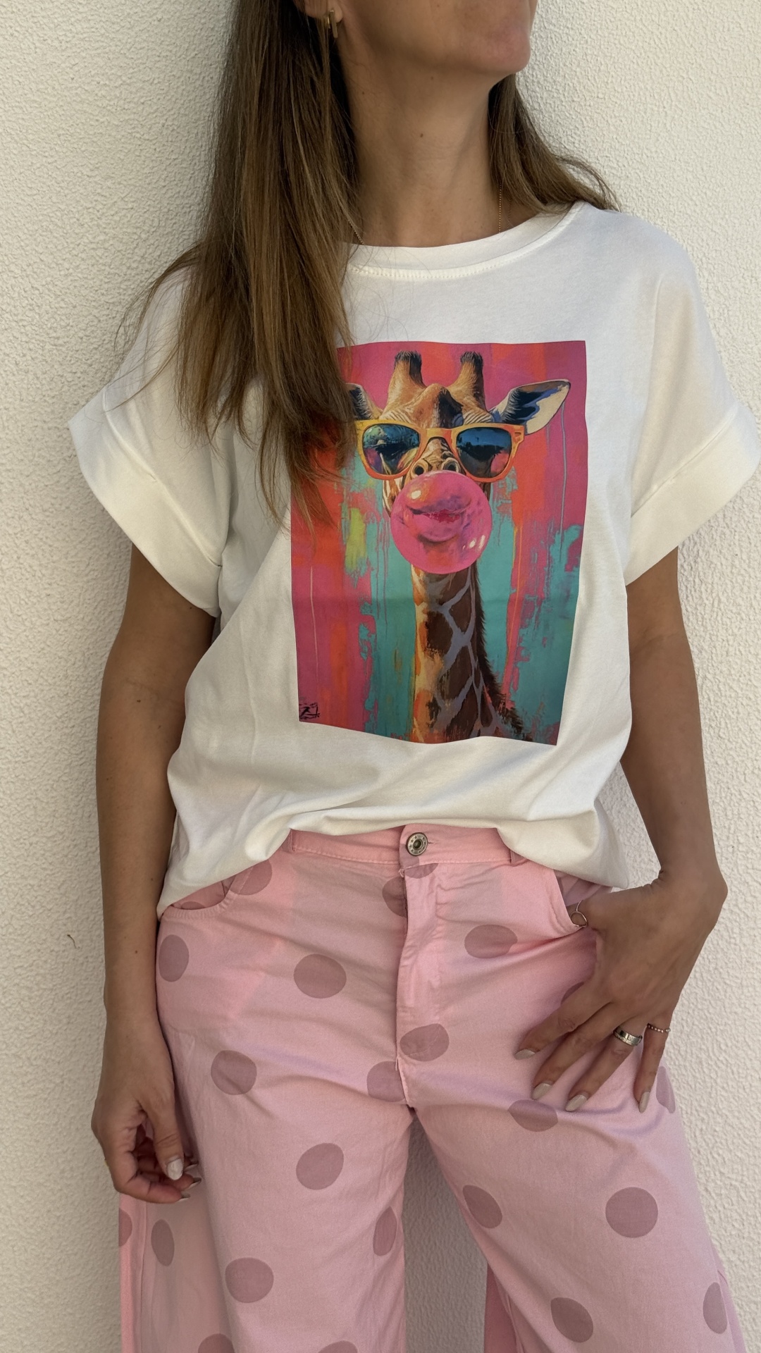 T-shirt branca com estampa de girafa e calças rosa às bolinhas