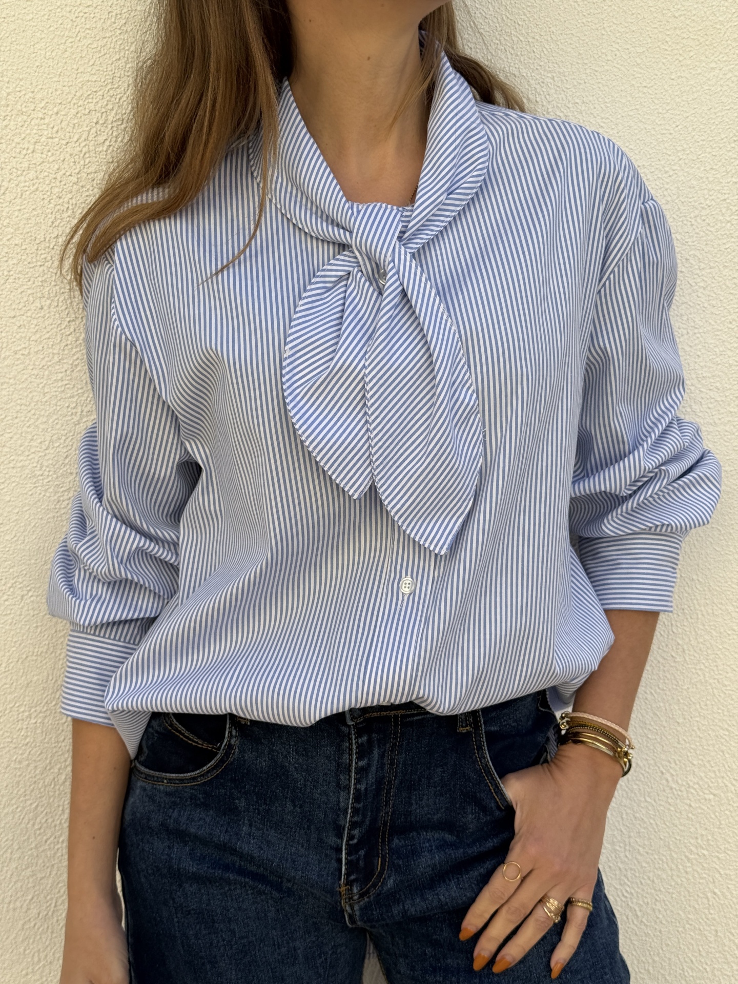 Camisa azul clara às riscas com laço ao colo e calças de ganga