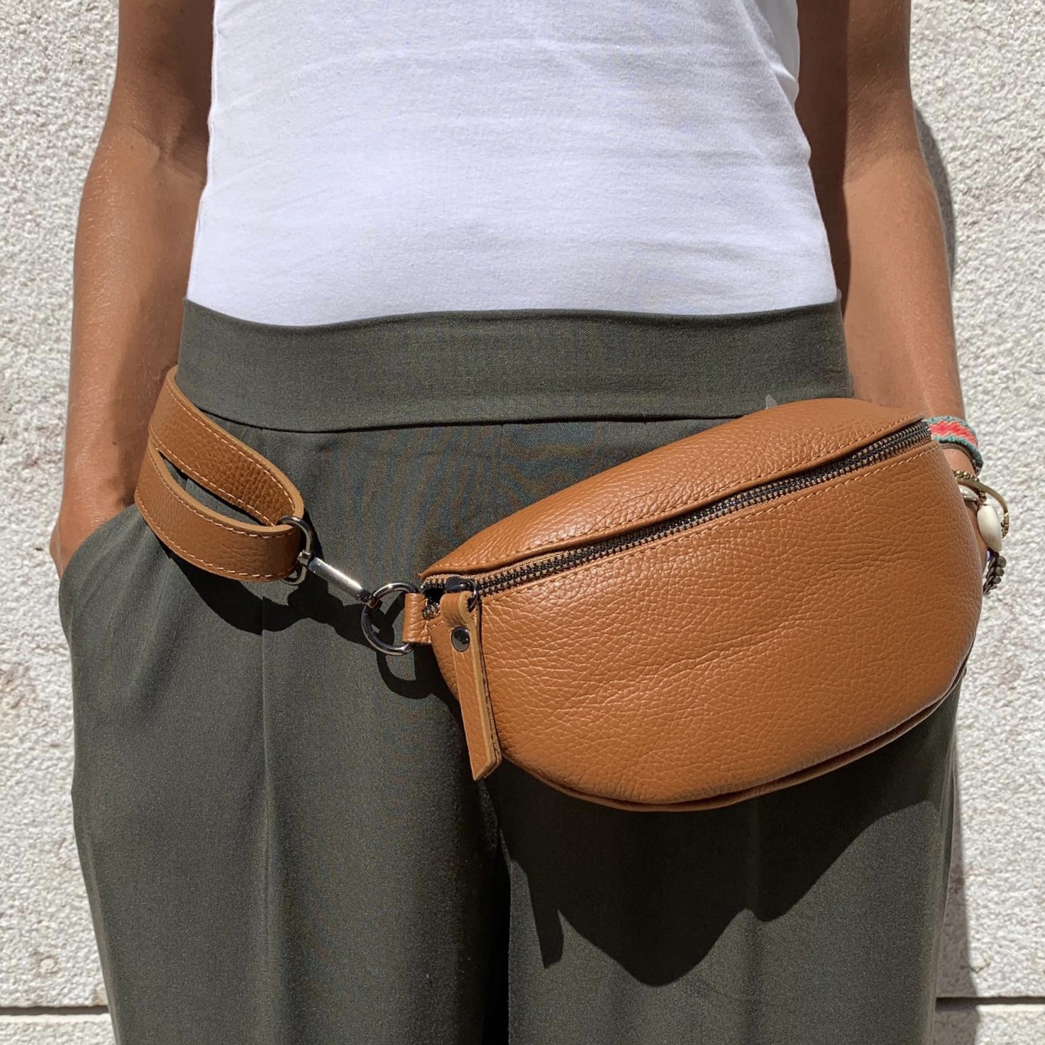 Bolsa cinto couro castanho usada na cintura com calças caqui e camiseta branca