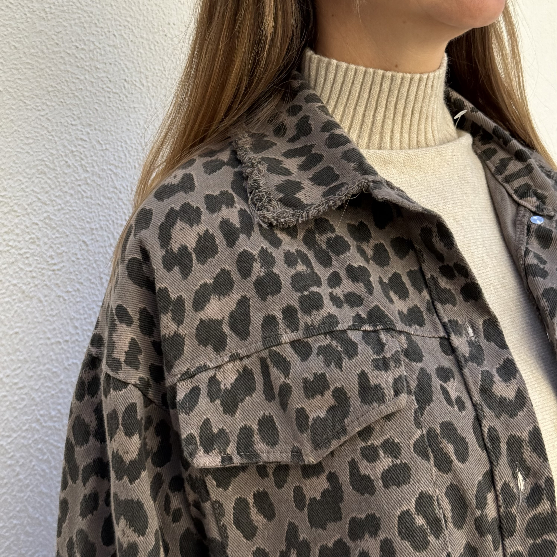 Casaco com padrão leopardo castanho e preto e camisola creme com gola alta