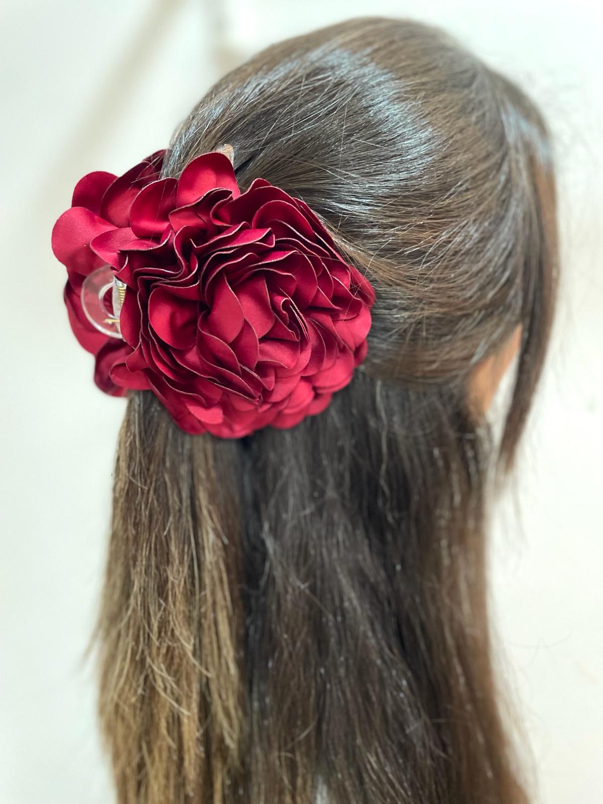 Prendedor de cabelo com flor vermelha em cabelo castanho