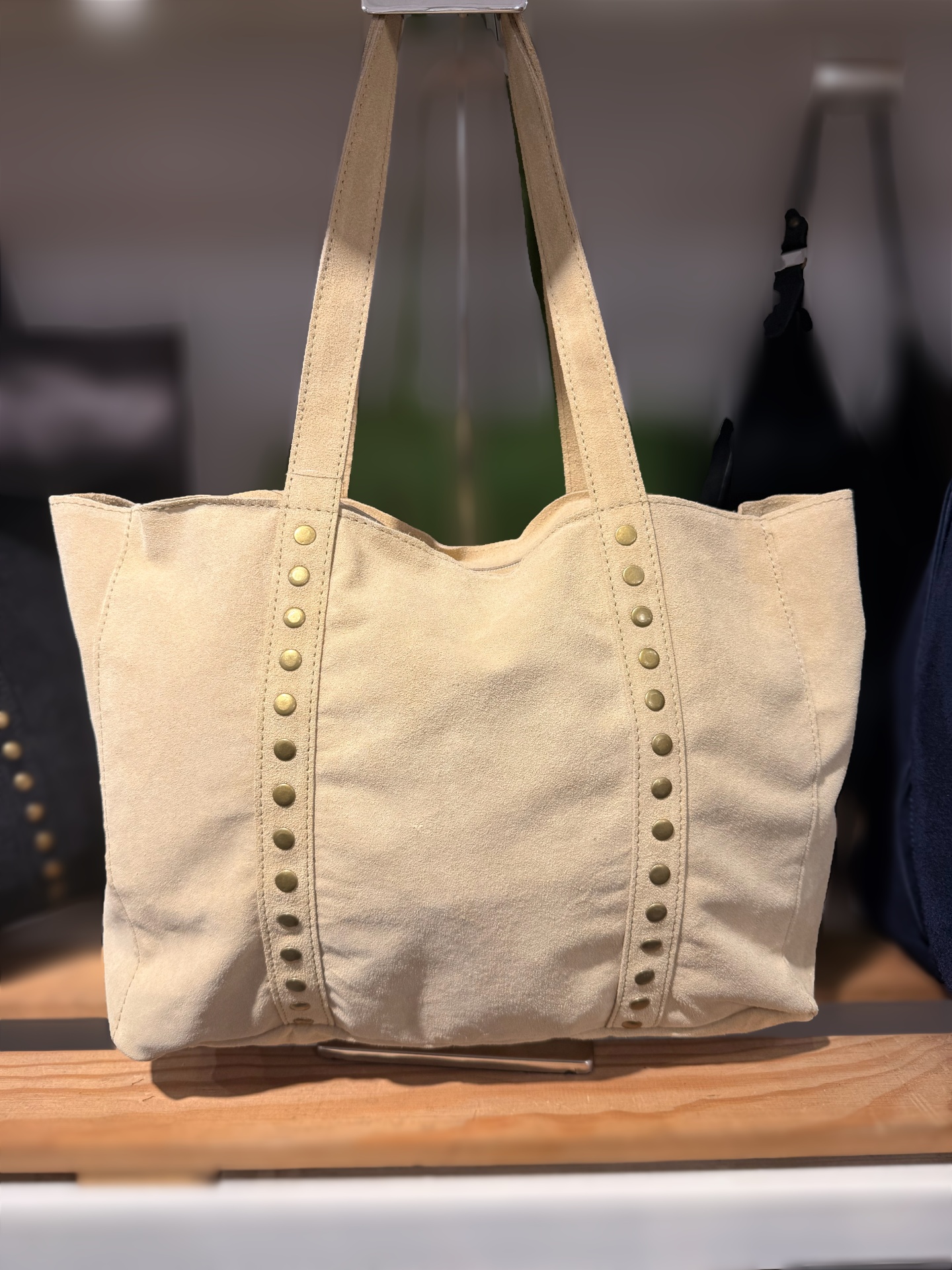 Mala tote bege com rebites metálicos e duas alças em pele macia