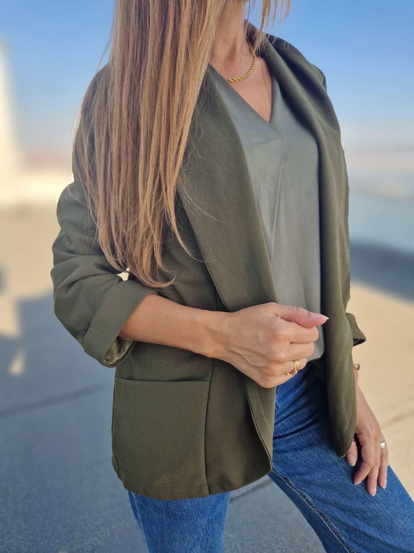 Blazer verde-oliva com bolso frontal e t-shirt cinza em ambiente urbano