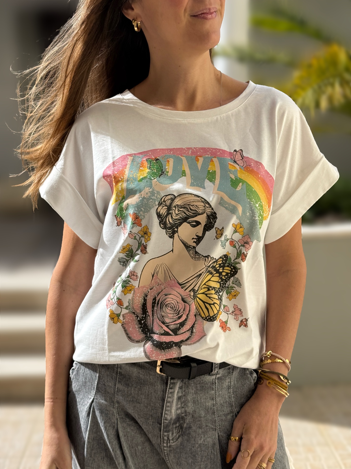 T-shirt branca com estampado colorido com texto LOVE e imagens florais e de mulher clássica