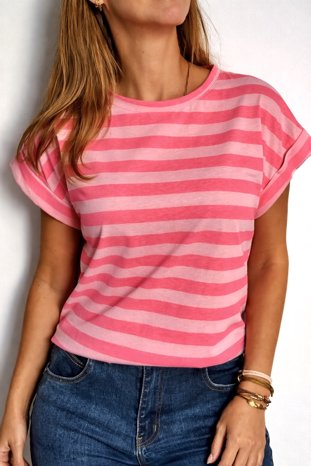 T-shirt rosa às riscas horizontais em modelo feminino com calças de ganga