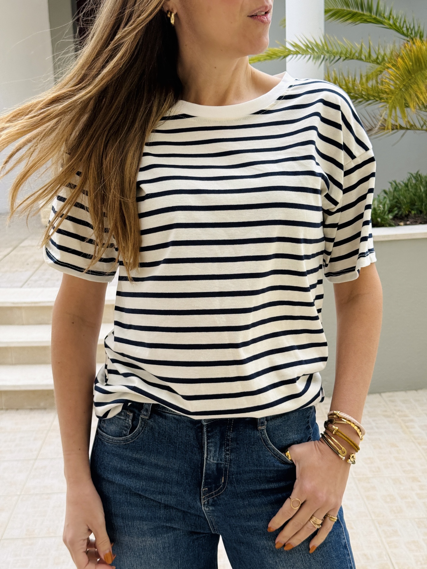 T-shirt riscada preta e branca com calças de ganga e acessórios dourados