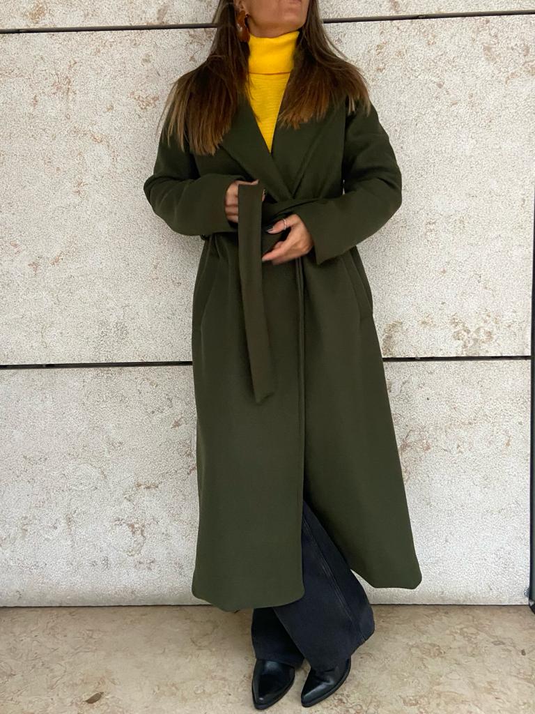 Casaco comprido verde-oliva com cinto e gola de lapela usado por mulher