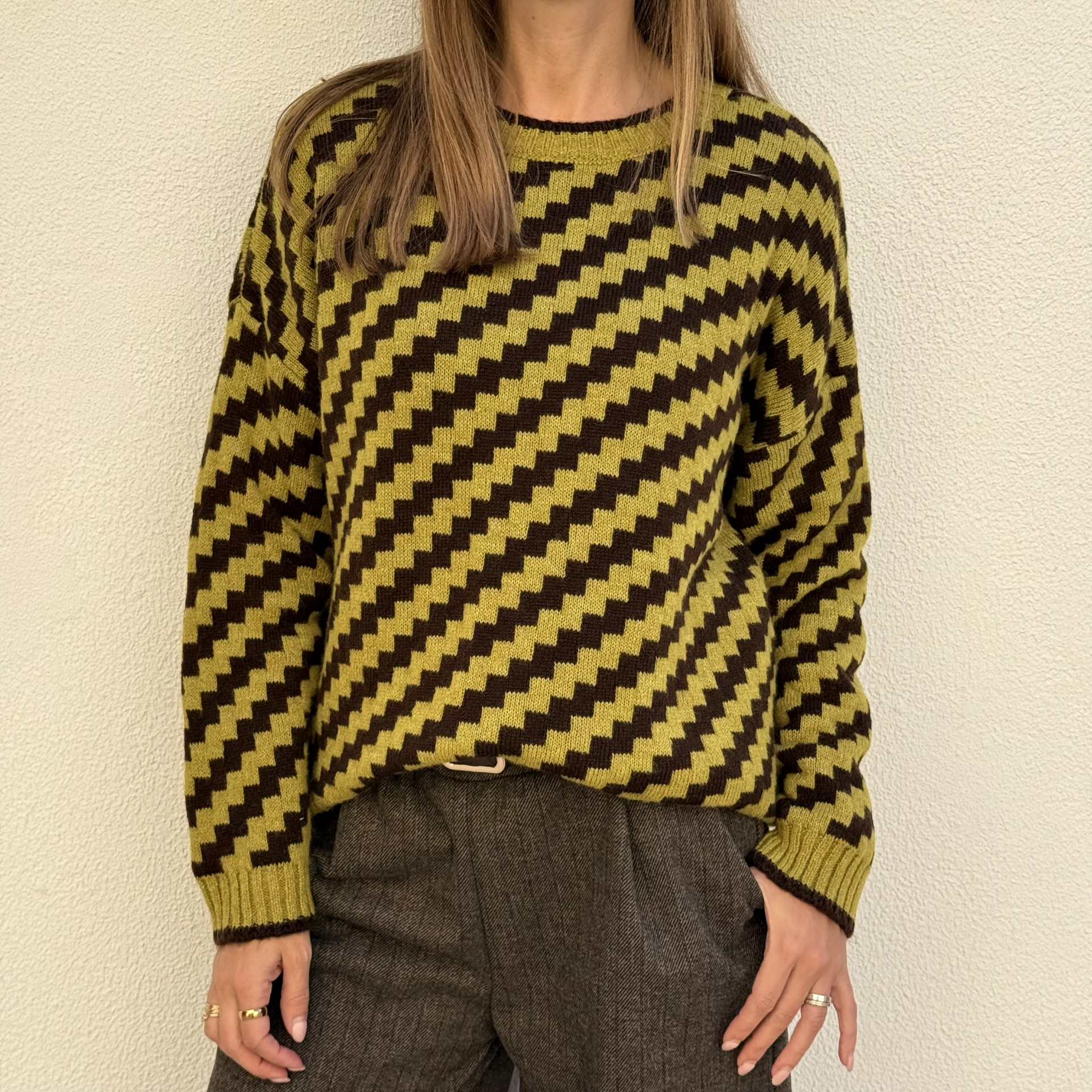 Camisola de malha verde-limão e castanha com padrão xadrez usada por mulher