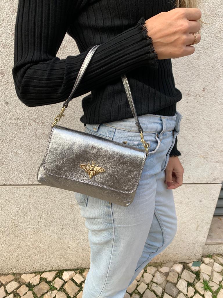 Mala de mão prateada em pele com adorno dourado em forma de inseto