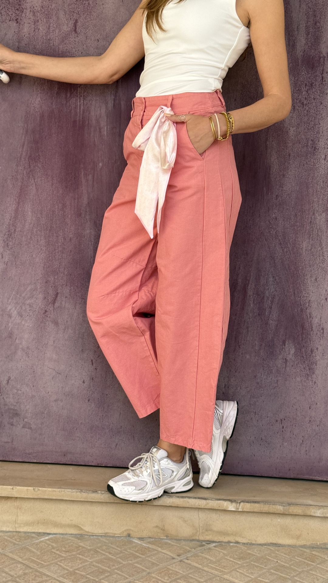 Calças rosa com cinto, top branco e ténis