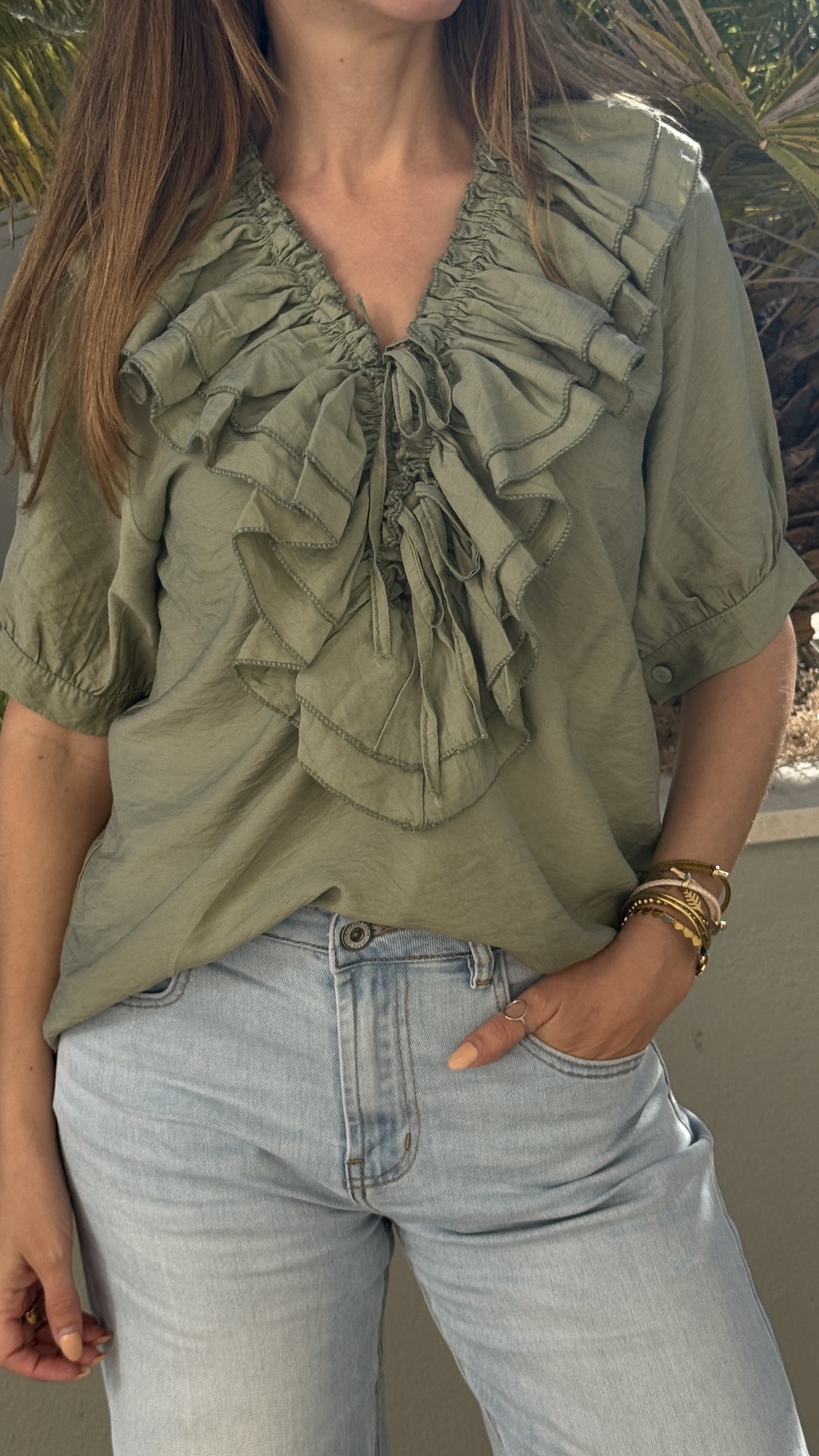 Blusa verde caqui com folhos e calças de ganga claras