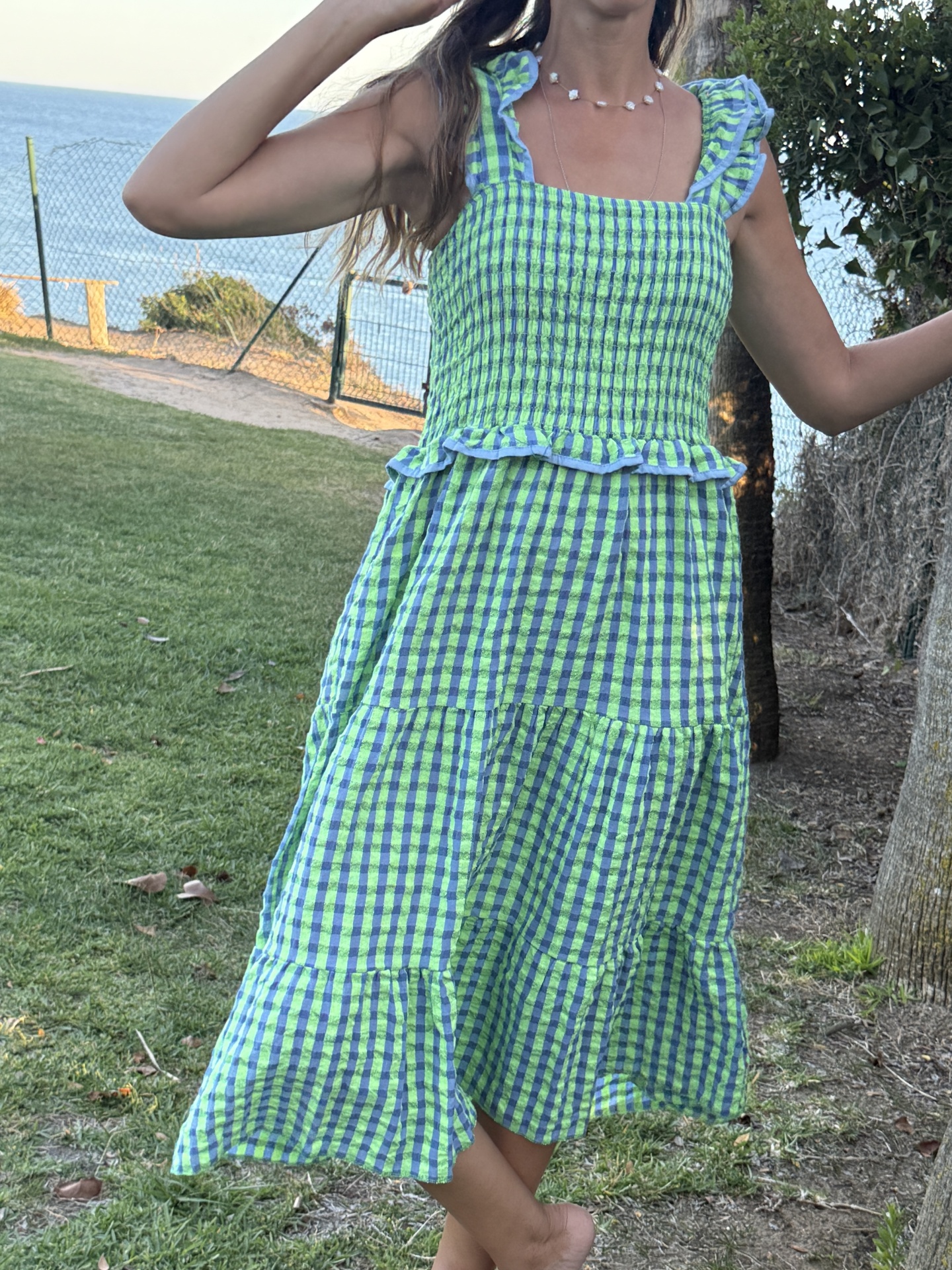 Vestido xadrez verde e azul com folhos em ambiente exterior