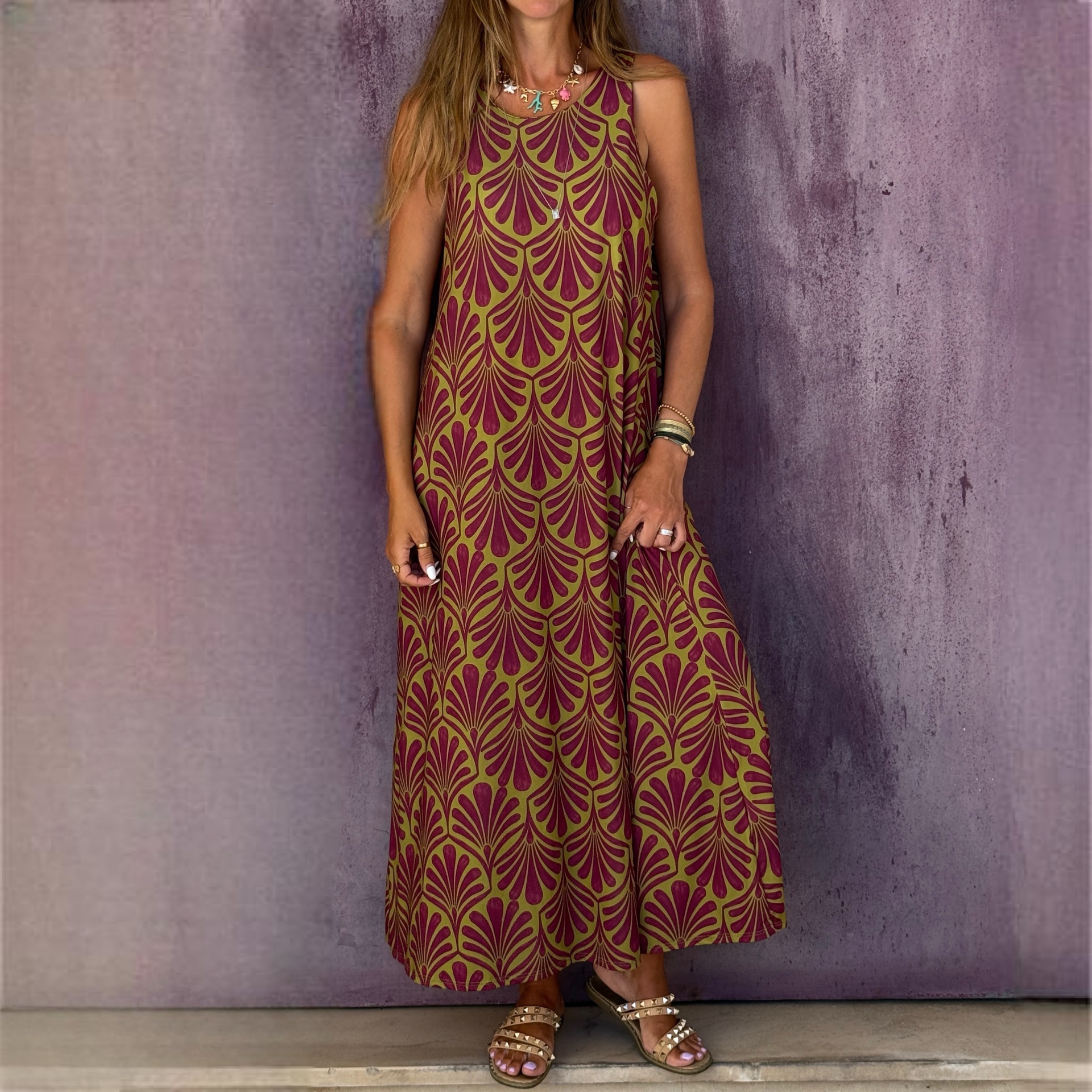 Vestido longo com padrão verde e vinho, acessórios e sandálias castanhas com tachas