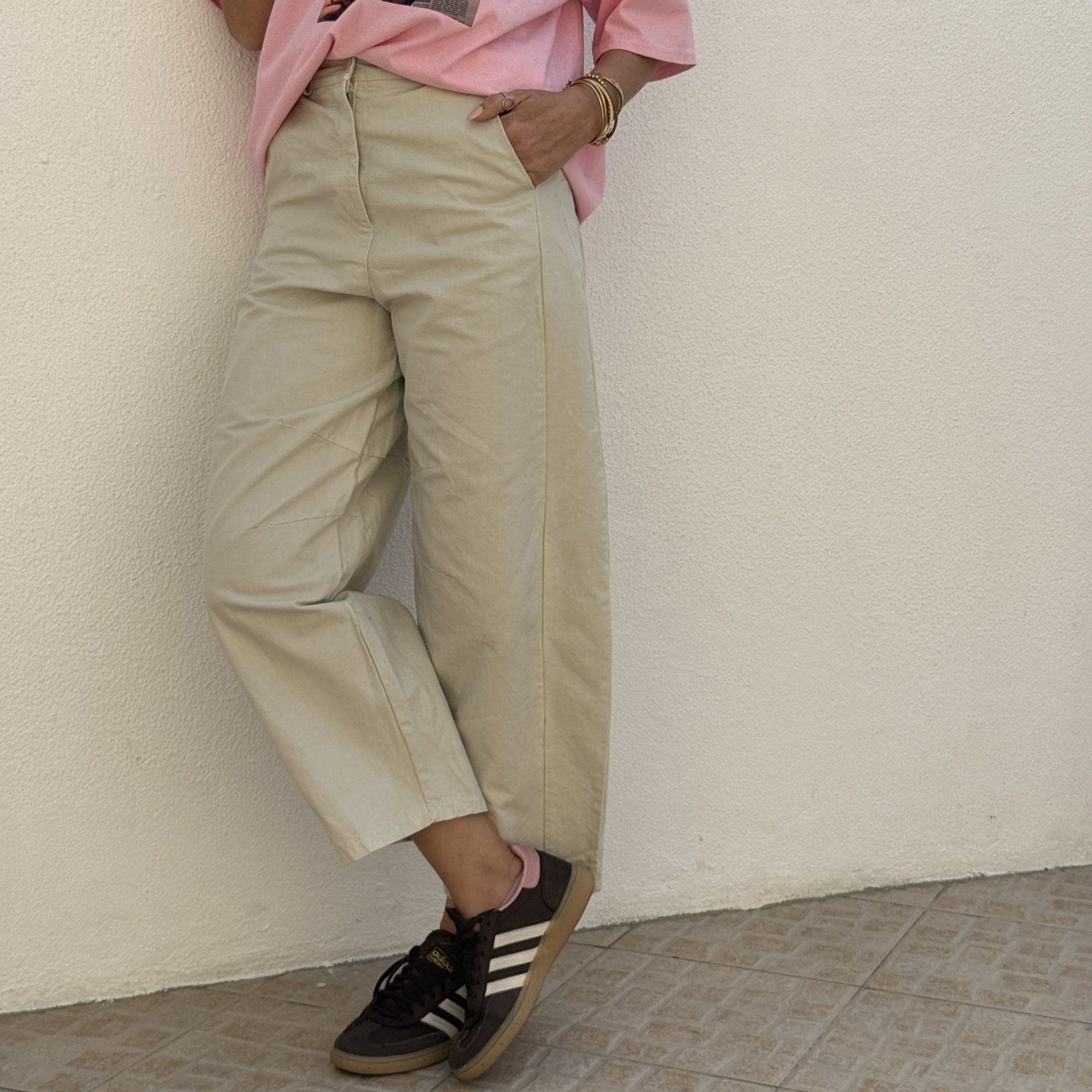 Calças bege largas com sapatilhas Adidas castanhas e t-shirt rosa