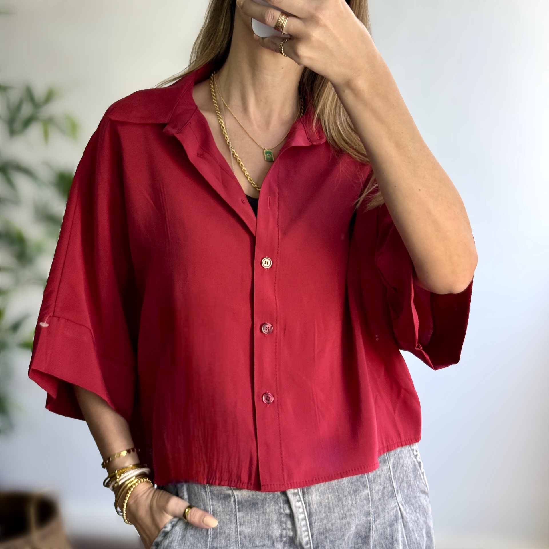 Camisa vermelha com botões e gola clássica em mulher com calças cinza