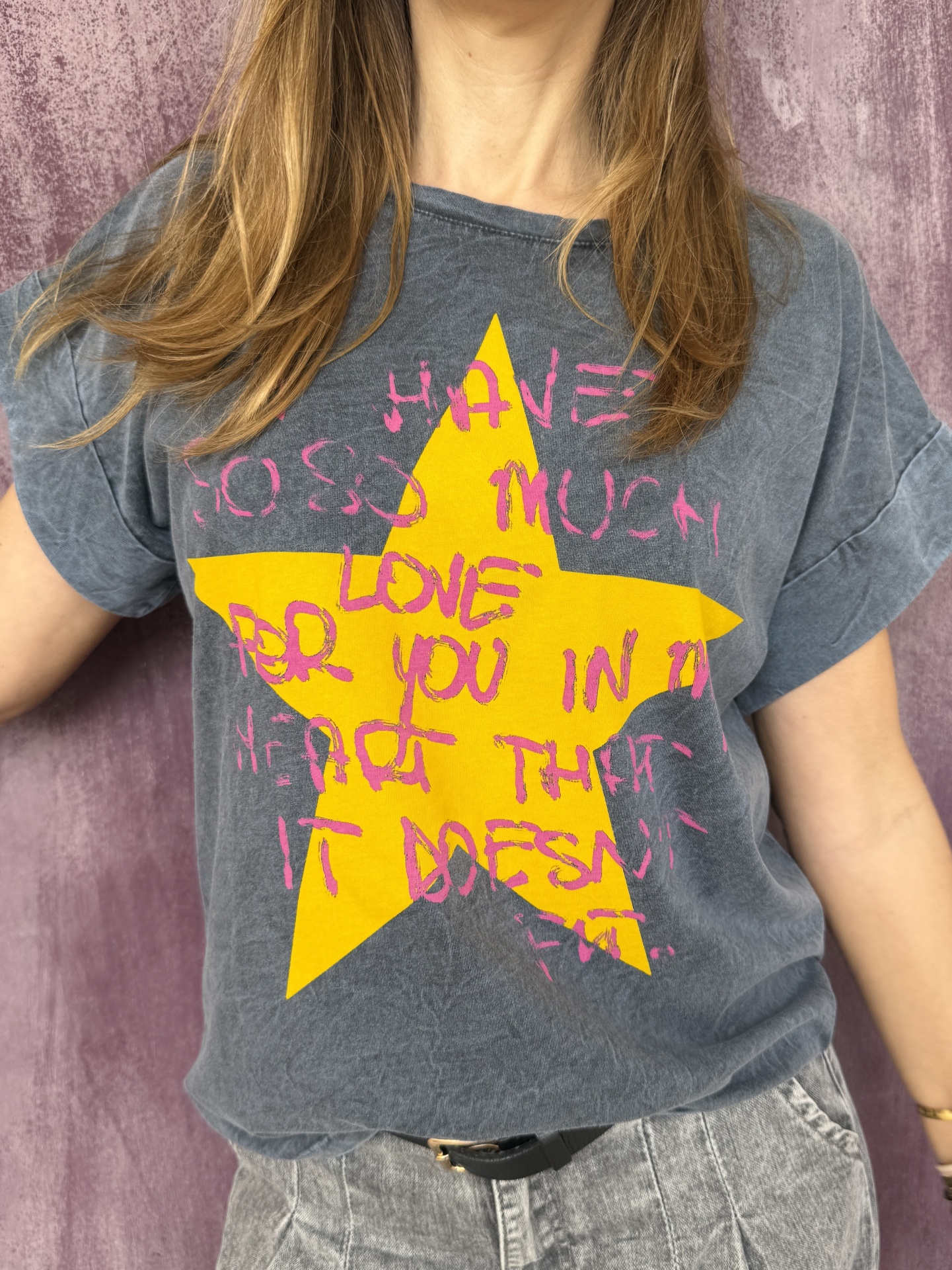 T-shirt cinza com estrela amarela e texto rosa