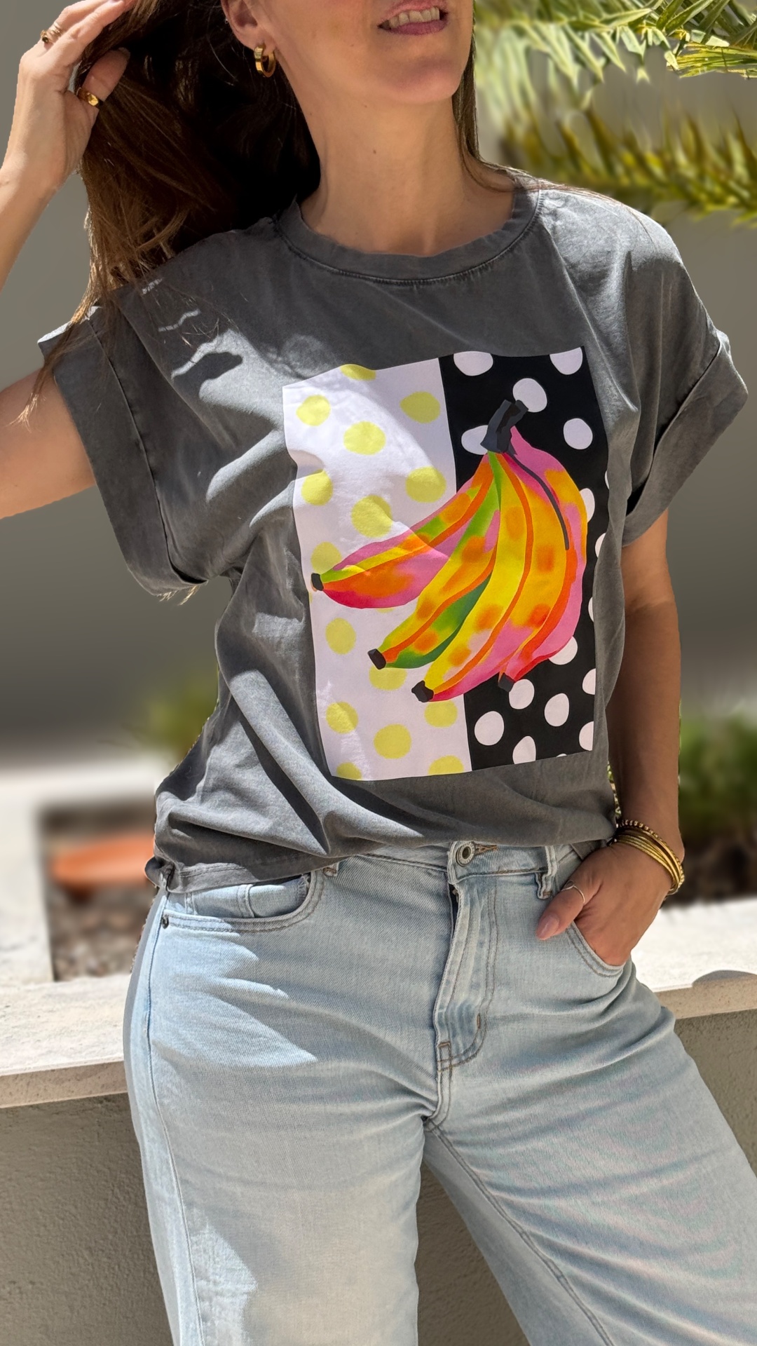T-shirt cinzenta com estampa de bananas coloridas e calças de ganga claras