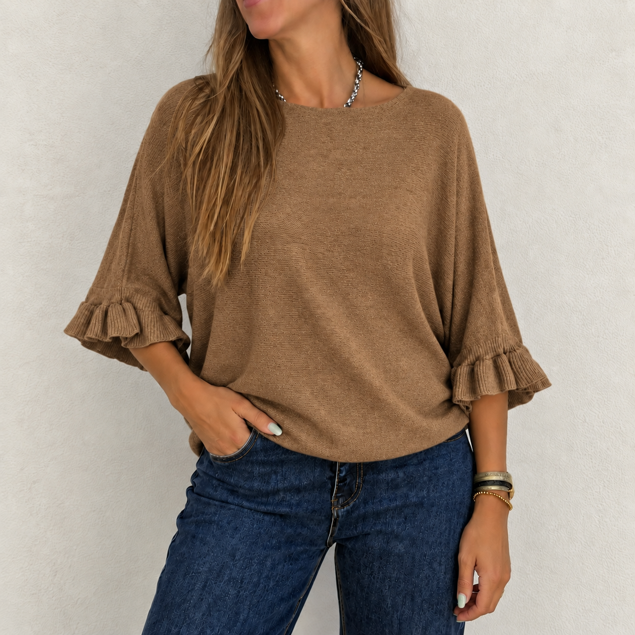 Camisola castanha de malha com folhos nas mangas e calças de ganga azuis