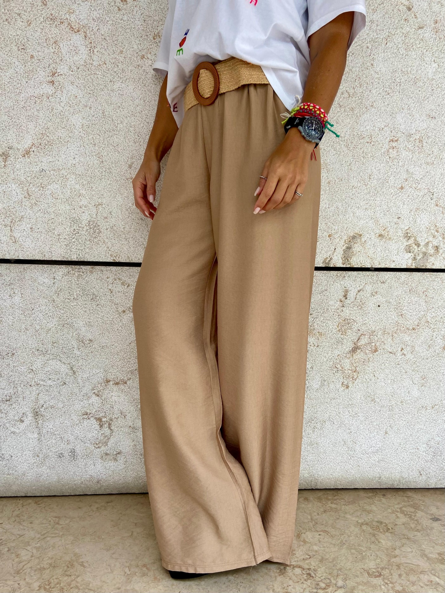 Calças largas castanhas com cinto trançado e t-shirt branca com flores coloridas