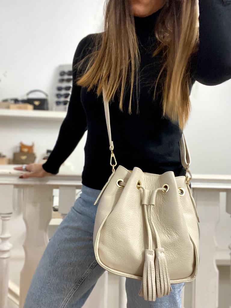 Mala saco em couro beige com tassel usada com roupa casual